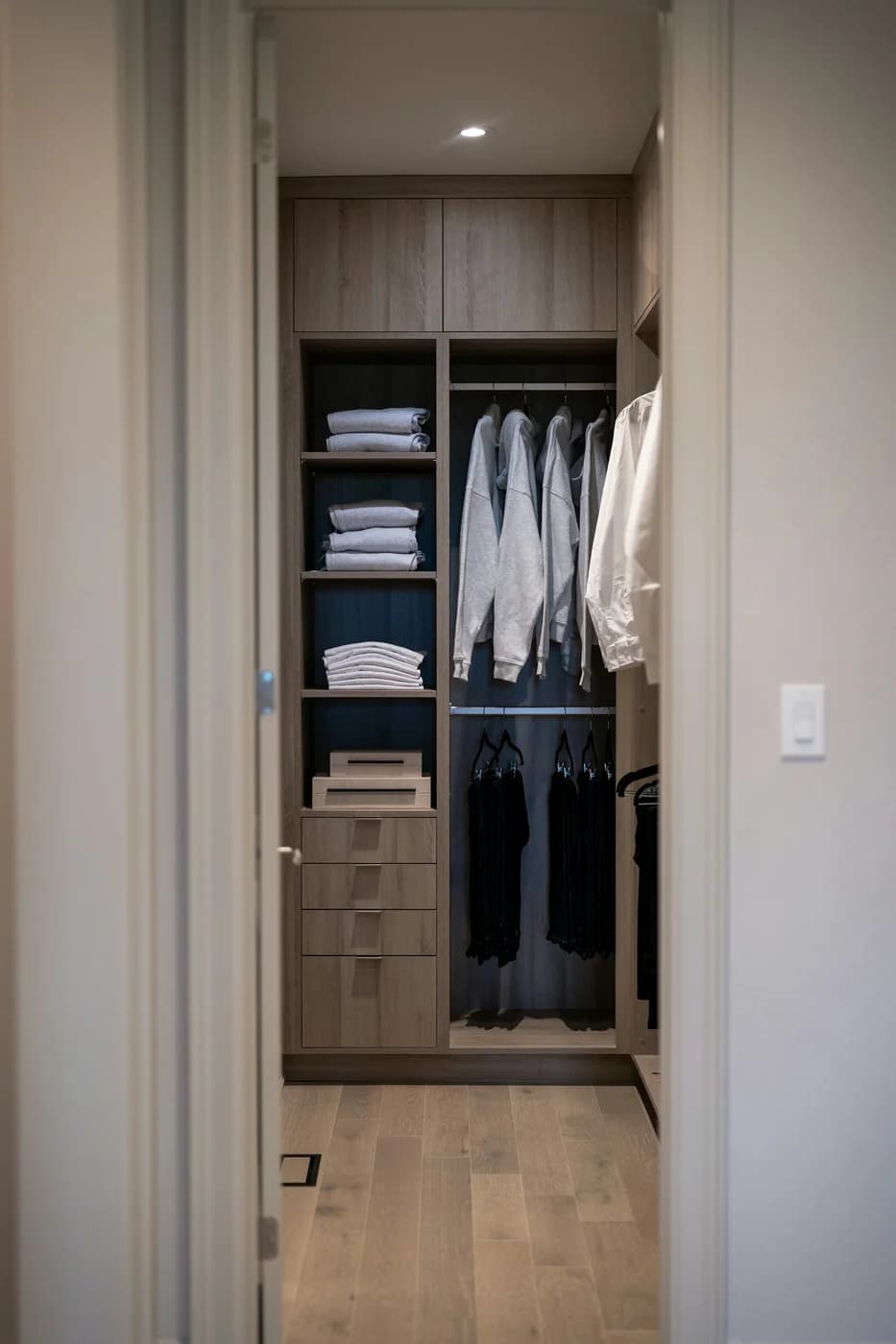 A fitted wardrobe with neatly arranged clothing, drawers and shelves at Order Custom Closets