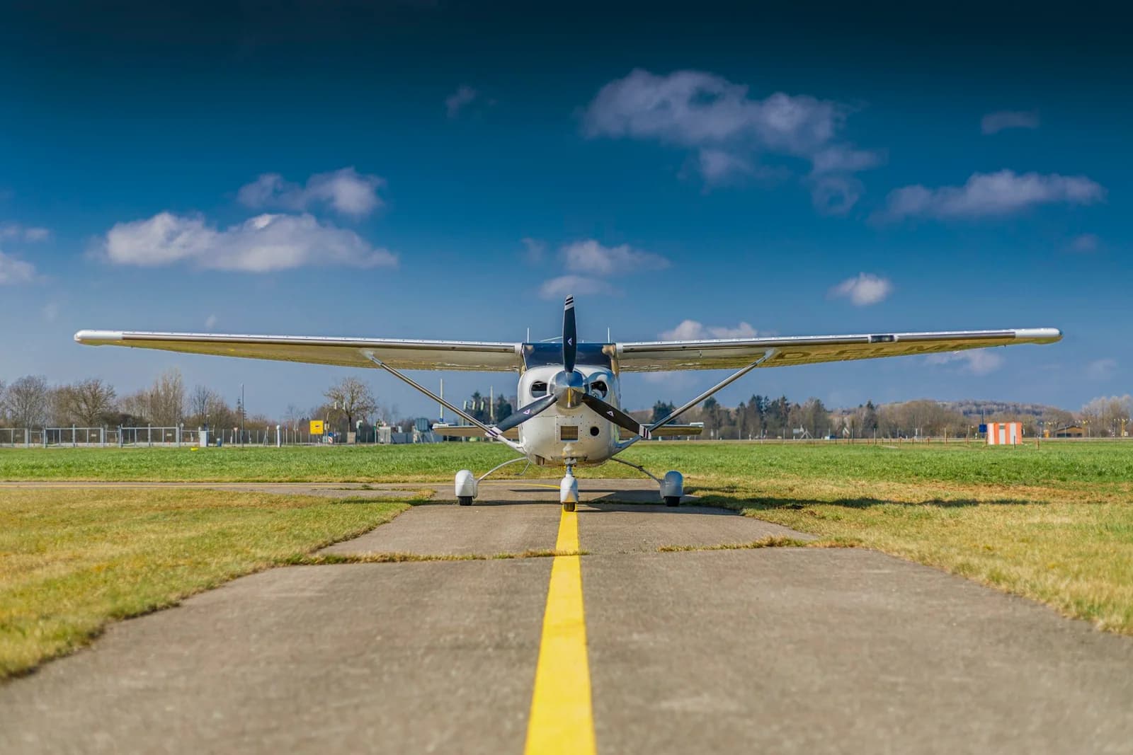 A light propeller aircraft facing the camera on an airport taxiway at Horizon Flight Academy