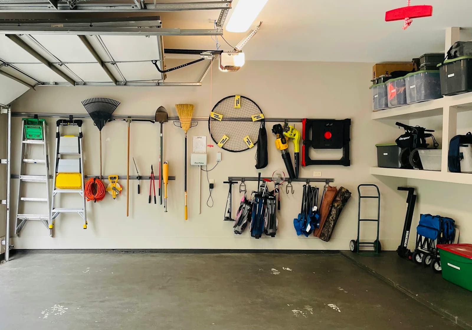 An organized garage with wall-mounted tools, bicycles and storage at Grid Garage Studio